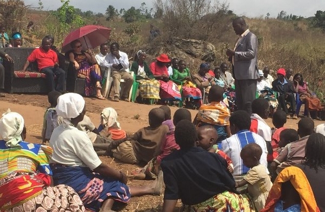 The VIPs and villagers listen to the Traditional Authority's acceptance speech